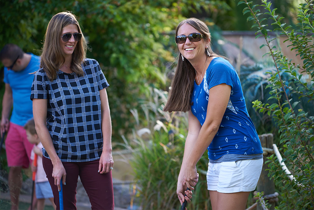 Two women playing mini golf