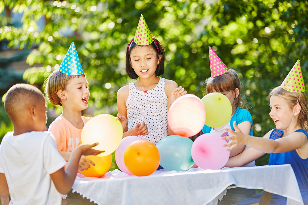 young children celebrating birthday with balloons